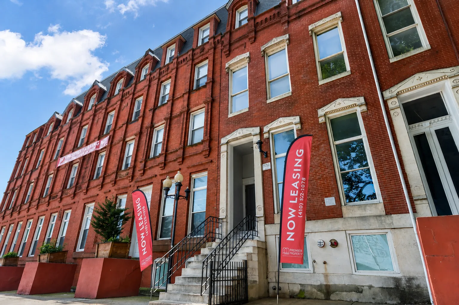 The McAllister brick apartment building on a sunny Baltimore street